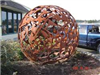 Large spherical metal sculpture titled 