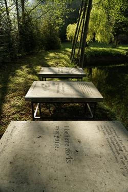 Three horizontal engraved side-by-side stone sculptures by artist Mizzonk